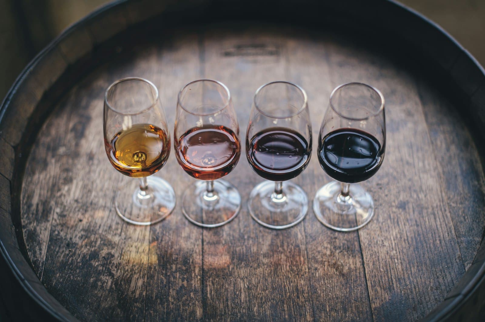 A tasting flight of four wines on a barrel head