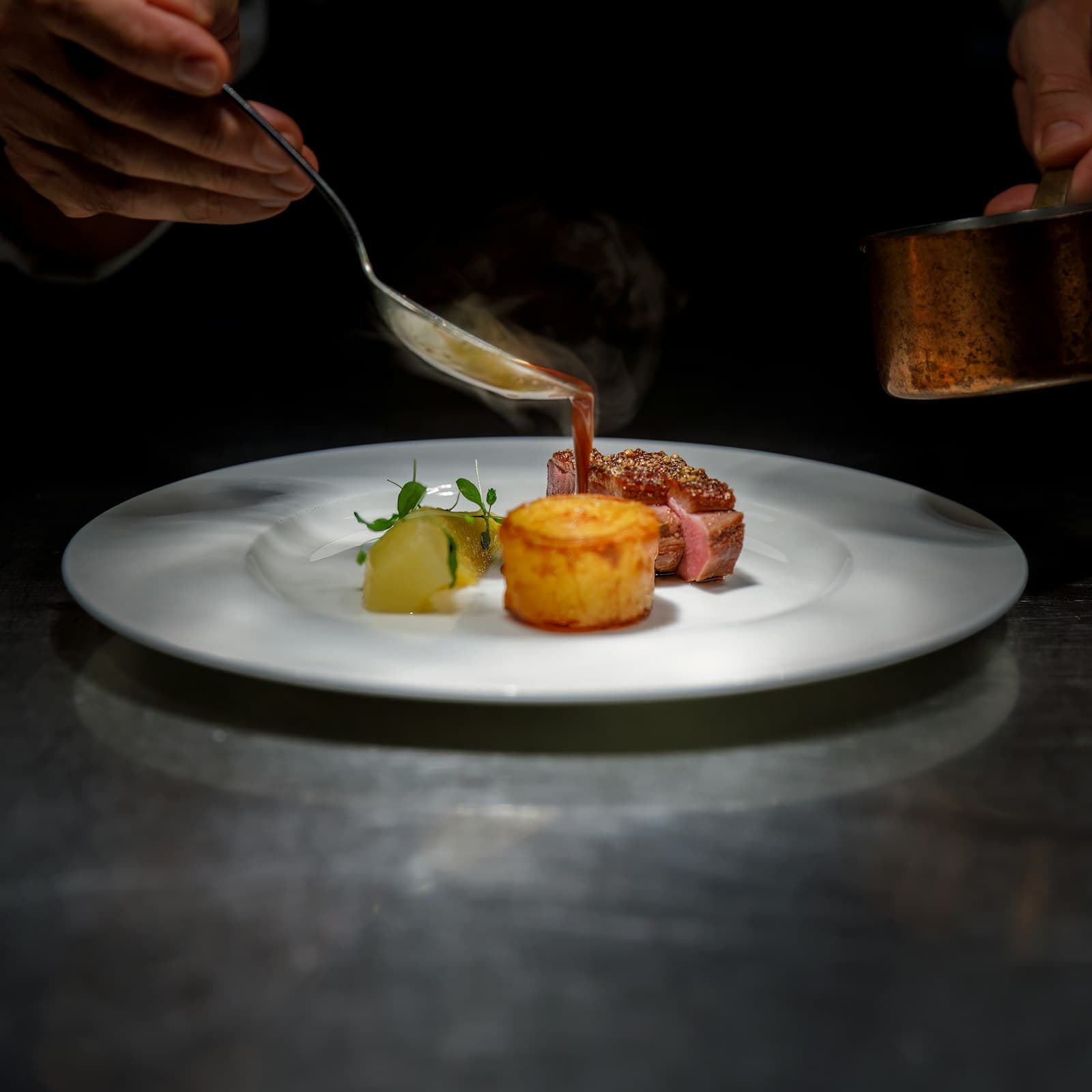 Dark mole sauce poured tableside over roasted pigeon