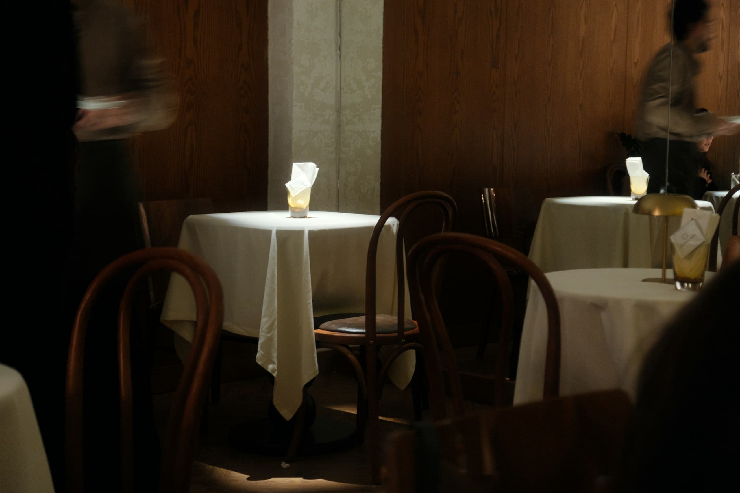 Candlelit tables dressed in white linen in the Paris dining room